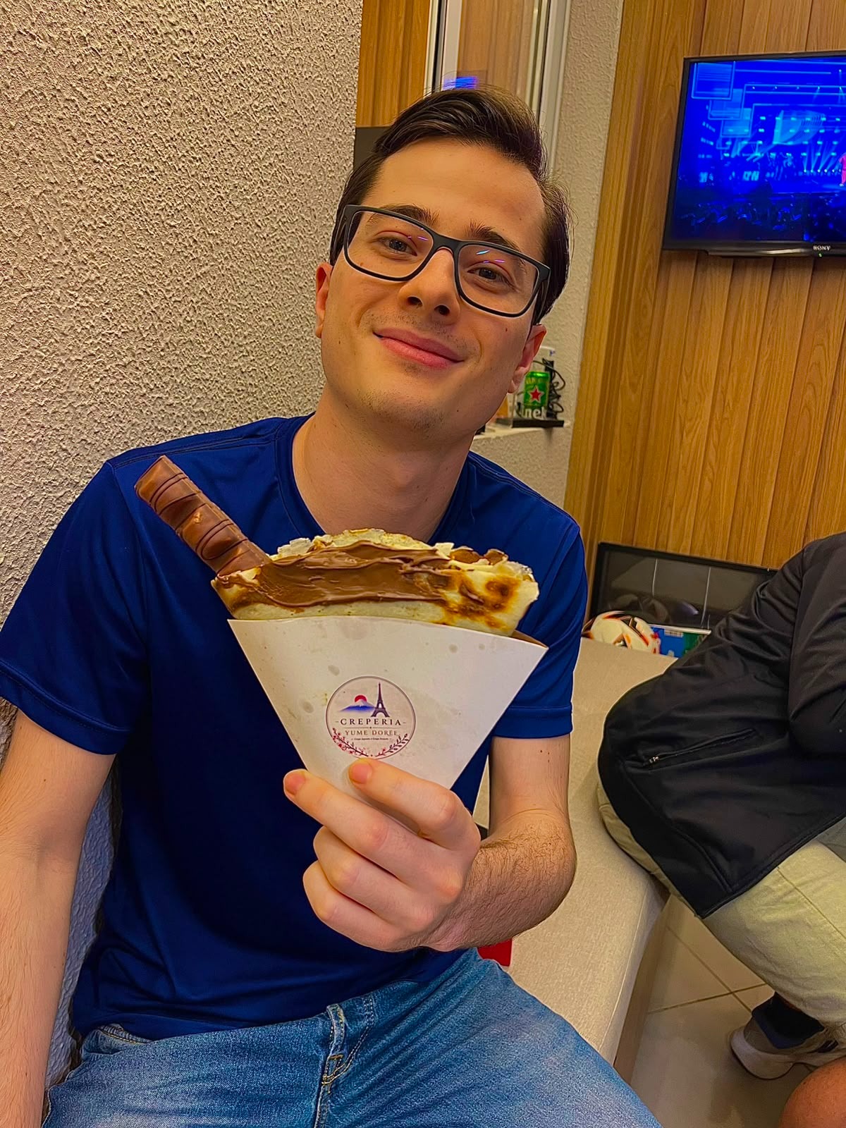 Convidado sorrindo com seu crepe de chocolate