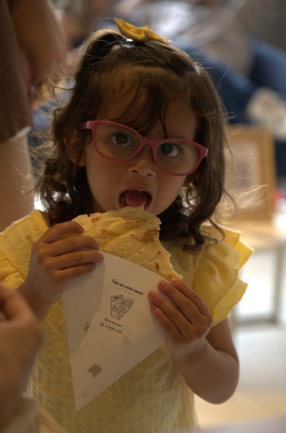 Menina saboreando um crepe na festa