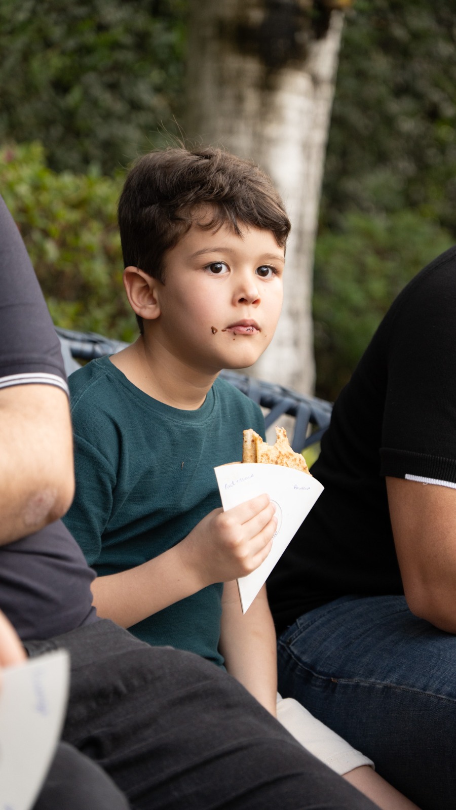 Menino saboreando um crepe ao ar livre