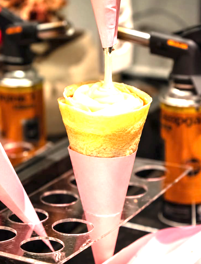 Crepe japonês em cone sendo finalizado com calda