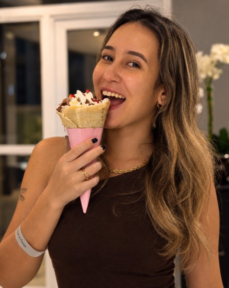 Convidada sorrindo com um cone japonês rosa na festa