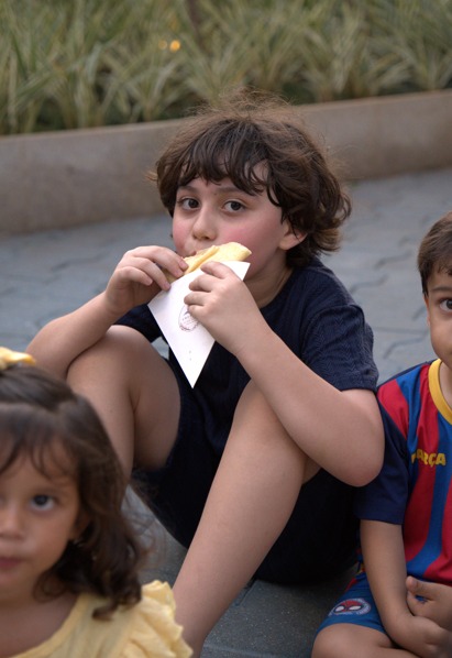 Menino comendo um crepe na festa