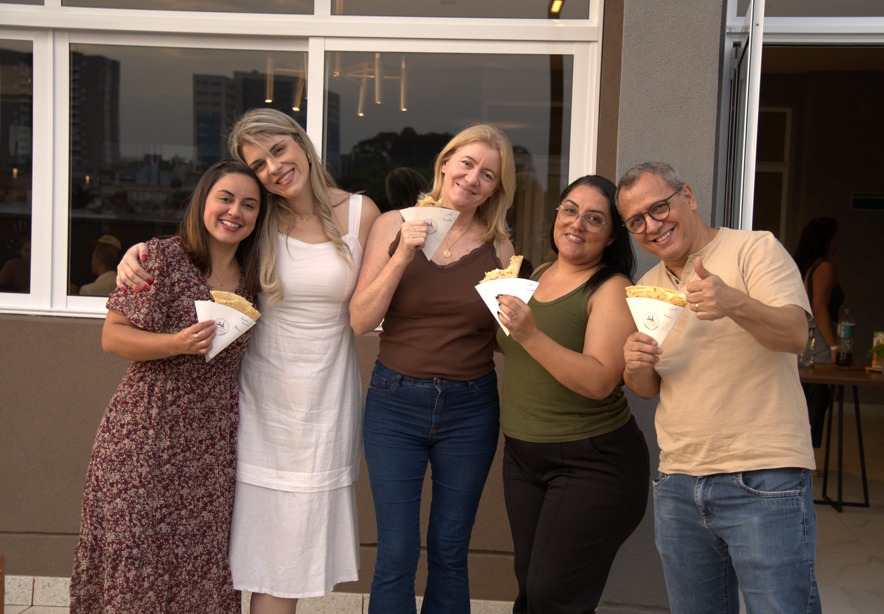 Convidados sorrindo juntos e segurando crepes Yume Dorée